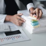 businessman looking through stacks of papers on de rrg587r (1)