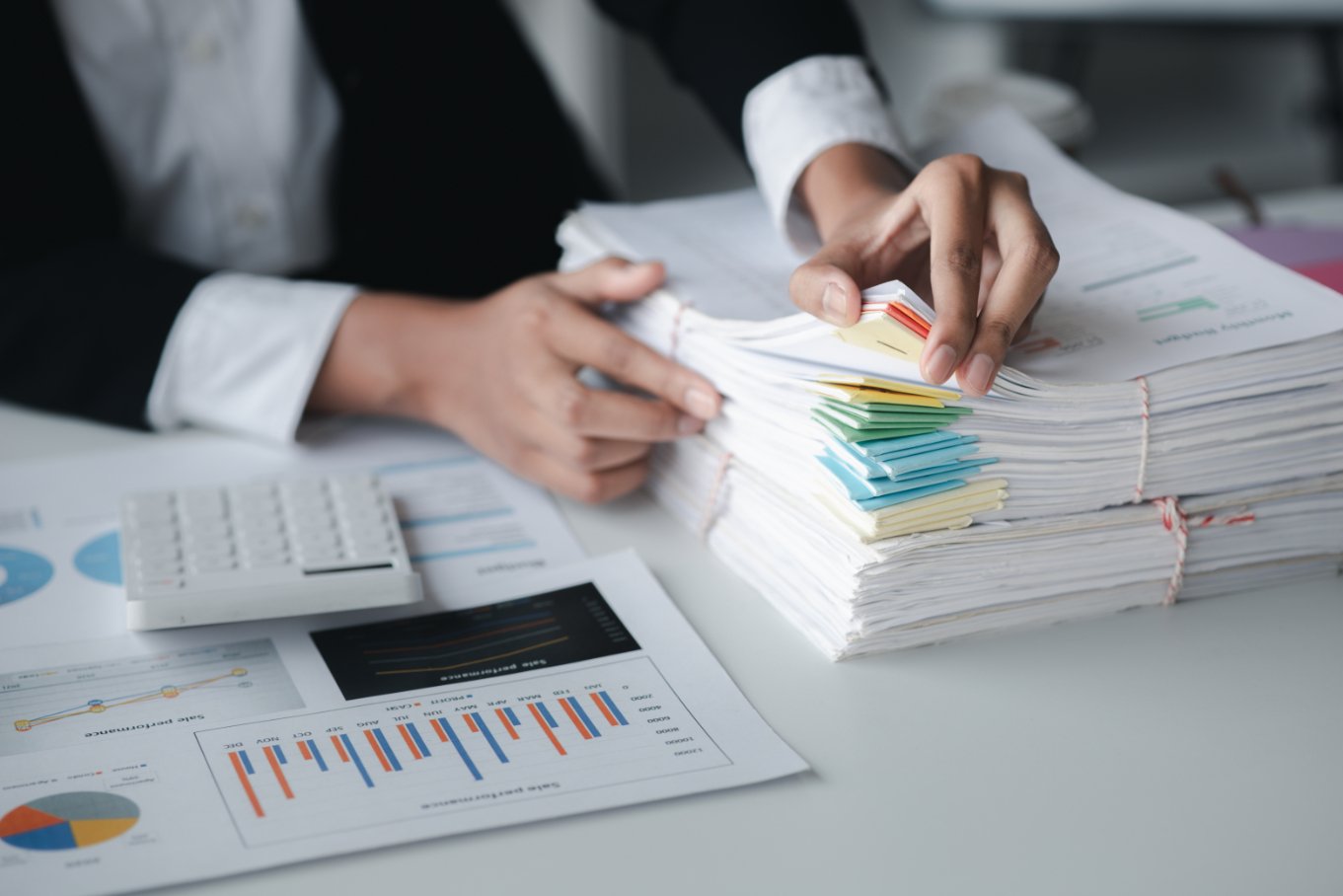 businessman looking through stacks of papers on de rrg587r (1)