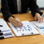 businesswoman working on document on business char 83bklp3 (1)